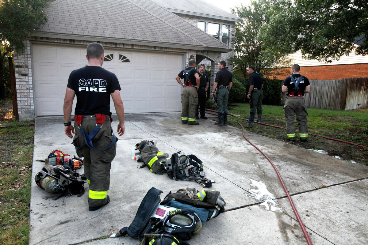 San Antonio firefighters work at the scene of an early morning house fire Thursday, Aug. 23, 2012, in the 7,700 block of Falcon Oak.