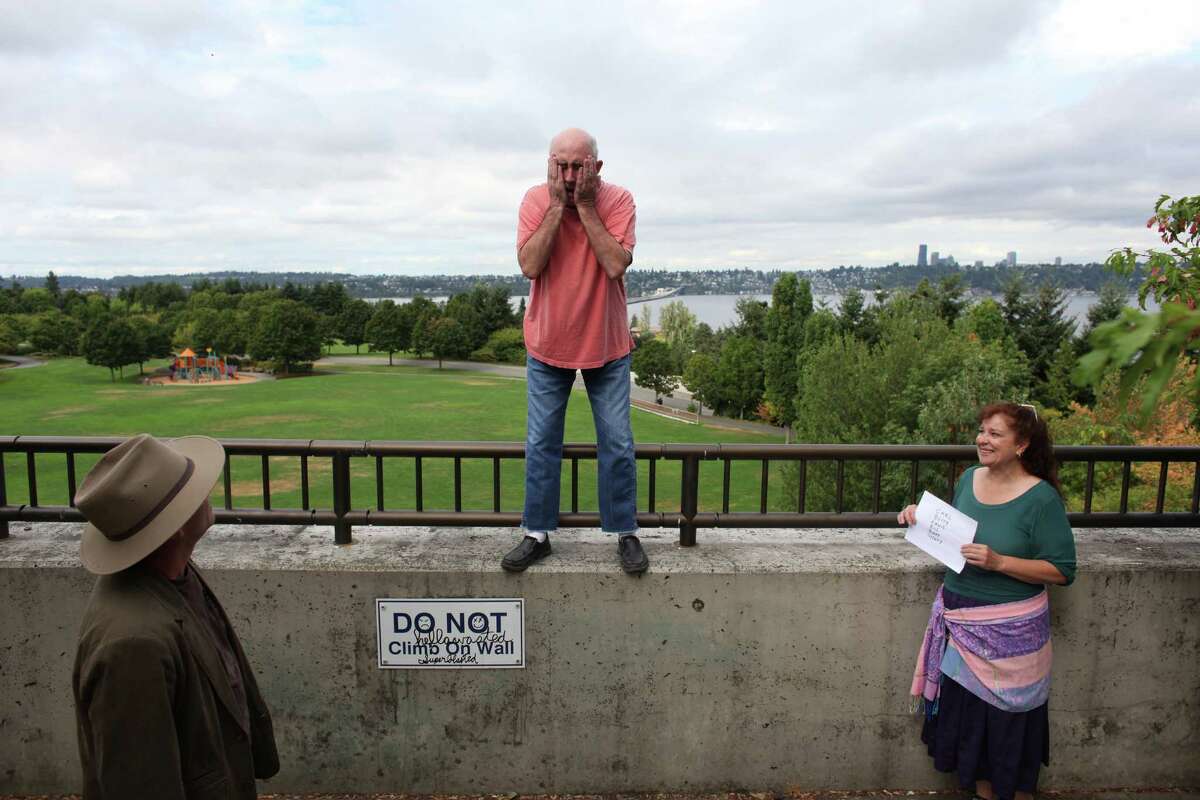 Comedian John Keister, center, practices a comedic sketch with Pat Cashman, left, as Keister's wife and show writer Mary McKinley holds up cues during a shoot for the new show "The (206)" on Thursday, August 23, 2012 at Mercer Island's Park on the Lid. The show is being produced by many of the original creators of popular television show "Almost Live" and will feature original comedic sketches.