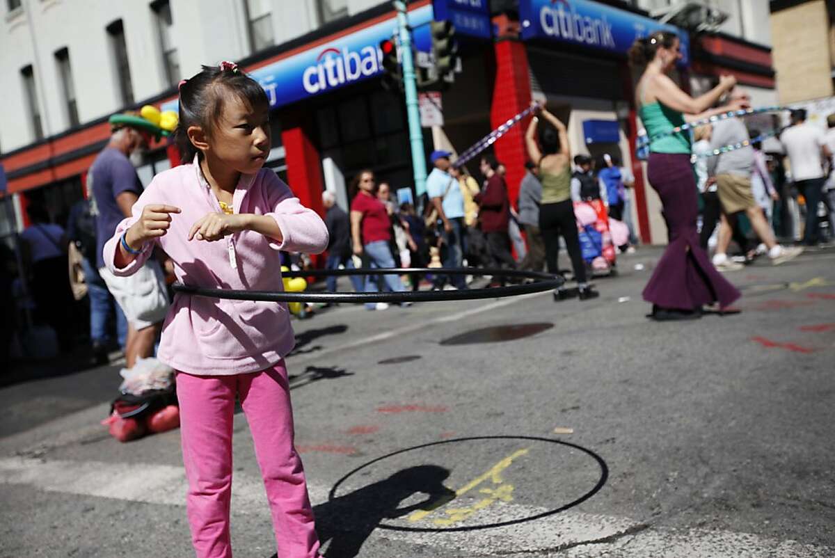 Alicia Chow, 7, plays with the hoop during the second annual Chinatown Sunday Streets in San Francisco, Calif. on Sunday, Aug 26, 2012.