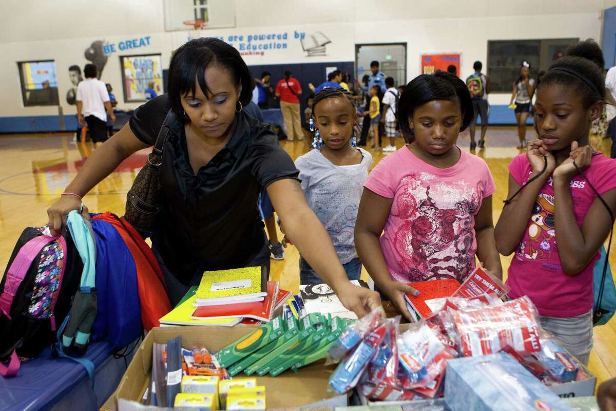 Rolanda Shaw, left, Cynai Christopher, 9, Bryanna Richardson, 11, and Sierra Jones, 11, check out school supplies during the fourth annual "Look Good, Feel Good" event at Fort Bend Boys and Girls Club.