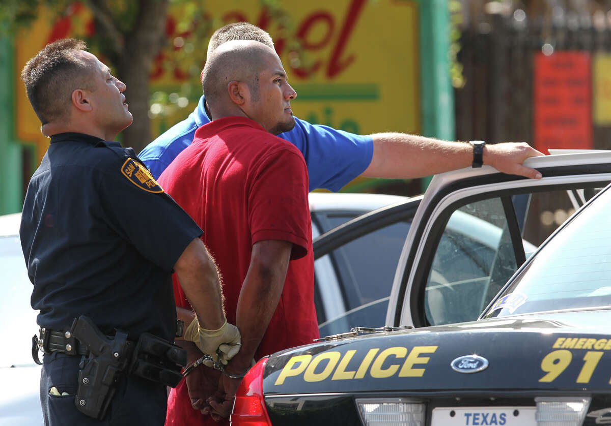 San Antonio police detain a suspect at the scene of a stabbing that took place Tuesday August 28, 2012 in front of Bonham Academy on S. St. Mary's street. Police said a woman was dropping her daughter off at the school when the man stabbed her. The woman is in critical condition.