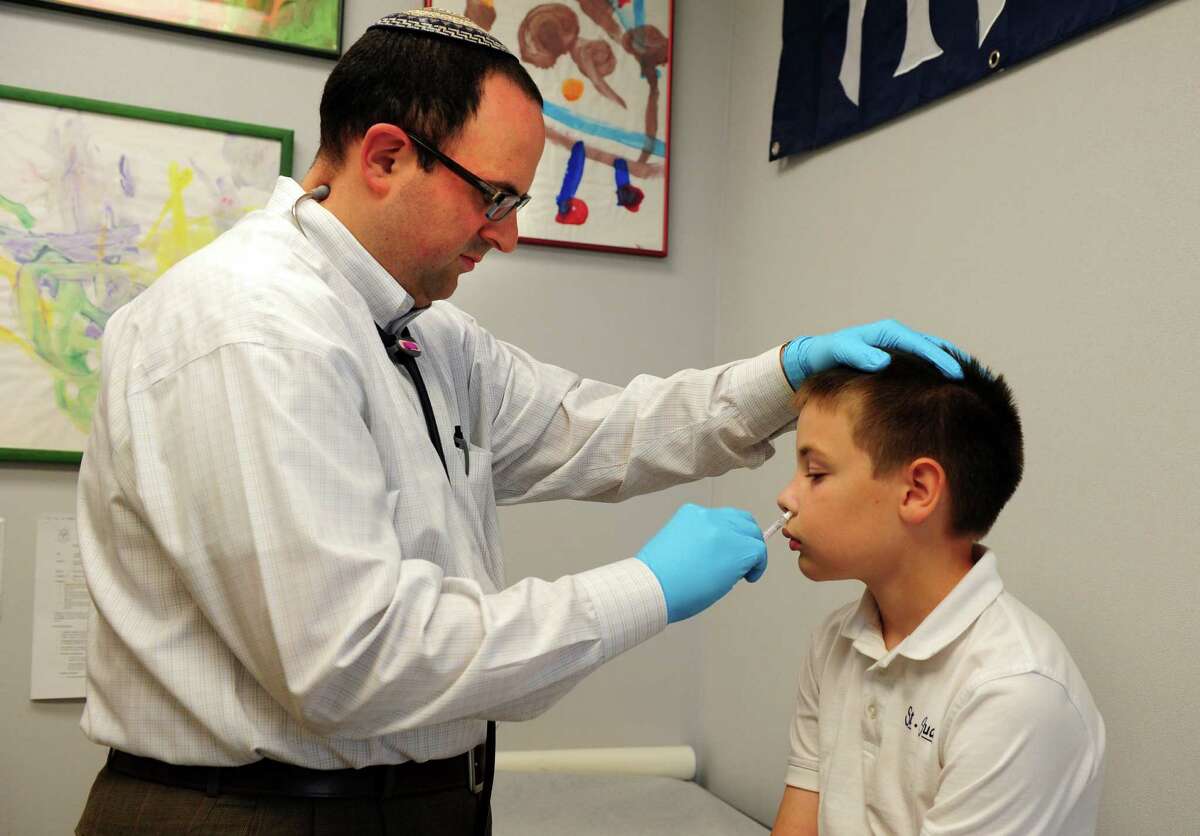 Dr. Nimrod Dayan administers a flu shot to eleven-year-old Chris Parkin Thursday, August 30, 2012 at Pediatric Healthcare Associates in Trumbull. Dayan, whose specialty is Pediatric Infectious Disease, feels strongly about the importance of vaccinations.