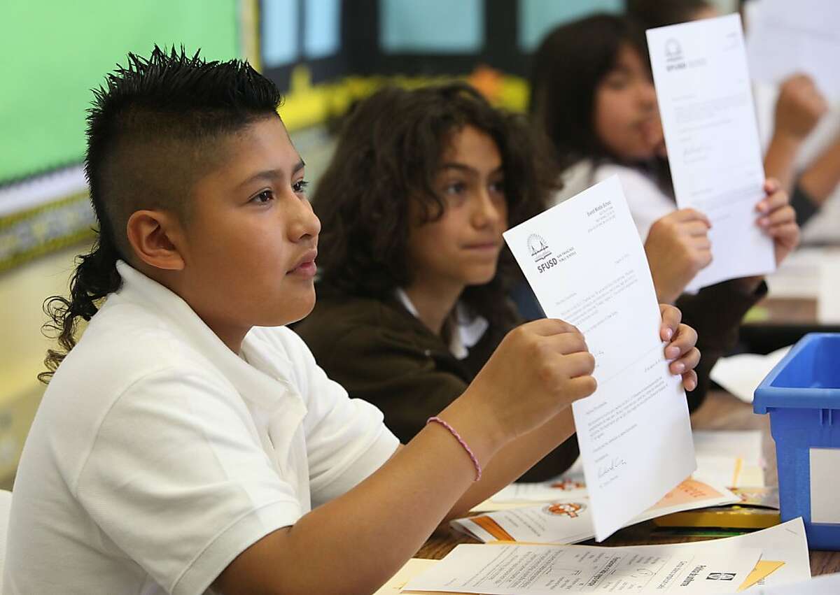 Sixth grader Geordan Chab (left), 11 years old, and Tulio Martinez (middle), 11 years old, going through student paper work during their first day of school at Everett Middle School in San Francisco, Calif., on Monday, August 20, 2012.