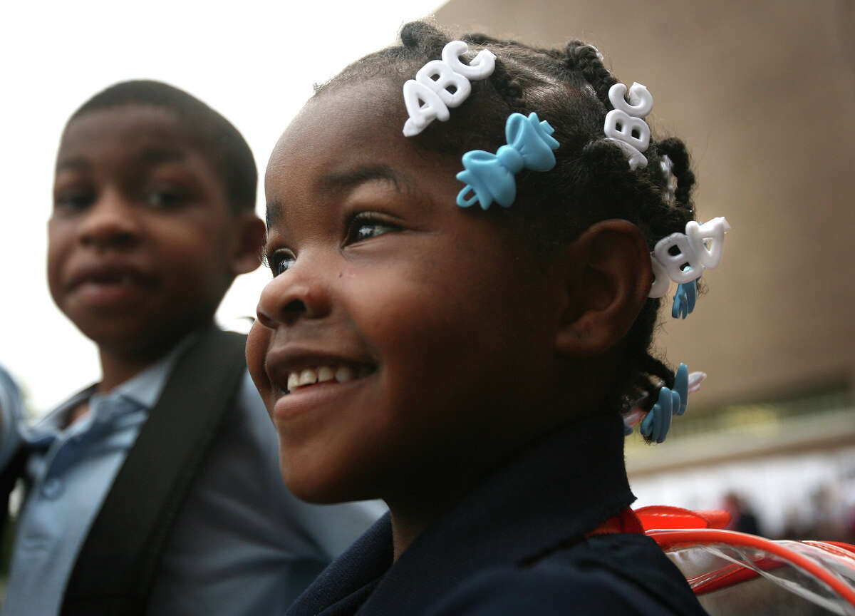 With her brother Nemo Wlliams, 7, left, Zy-maria Williams, 5, arrives for her first day of kindergarten at Curiale School in Bridgeport on Tuesday, August 28, 2012.