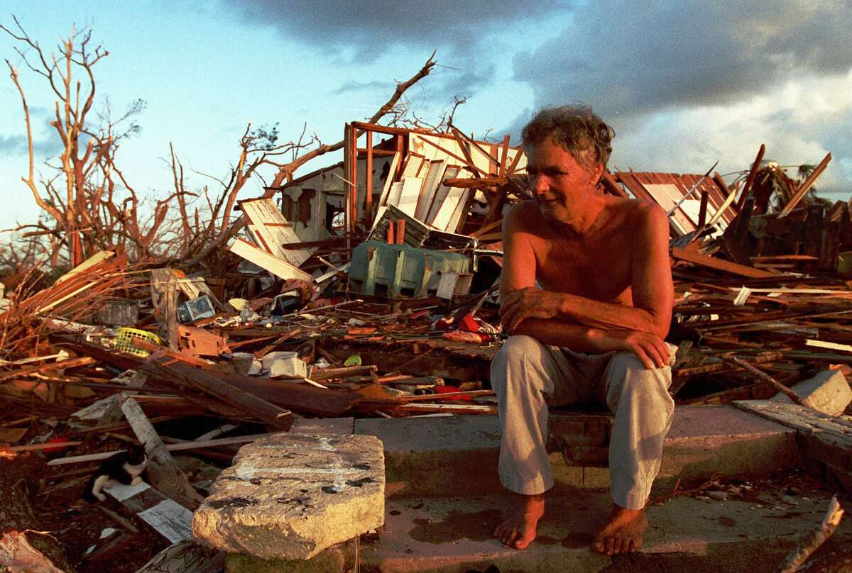 A Florida City man sits in the debris that was once his house after Hurricane Andrew in 1992.