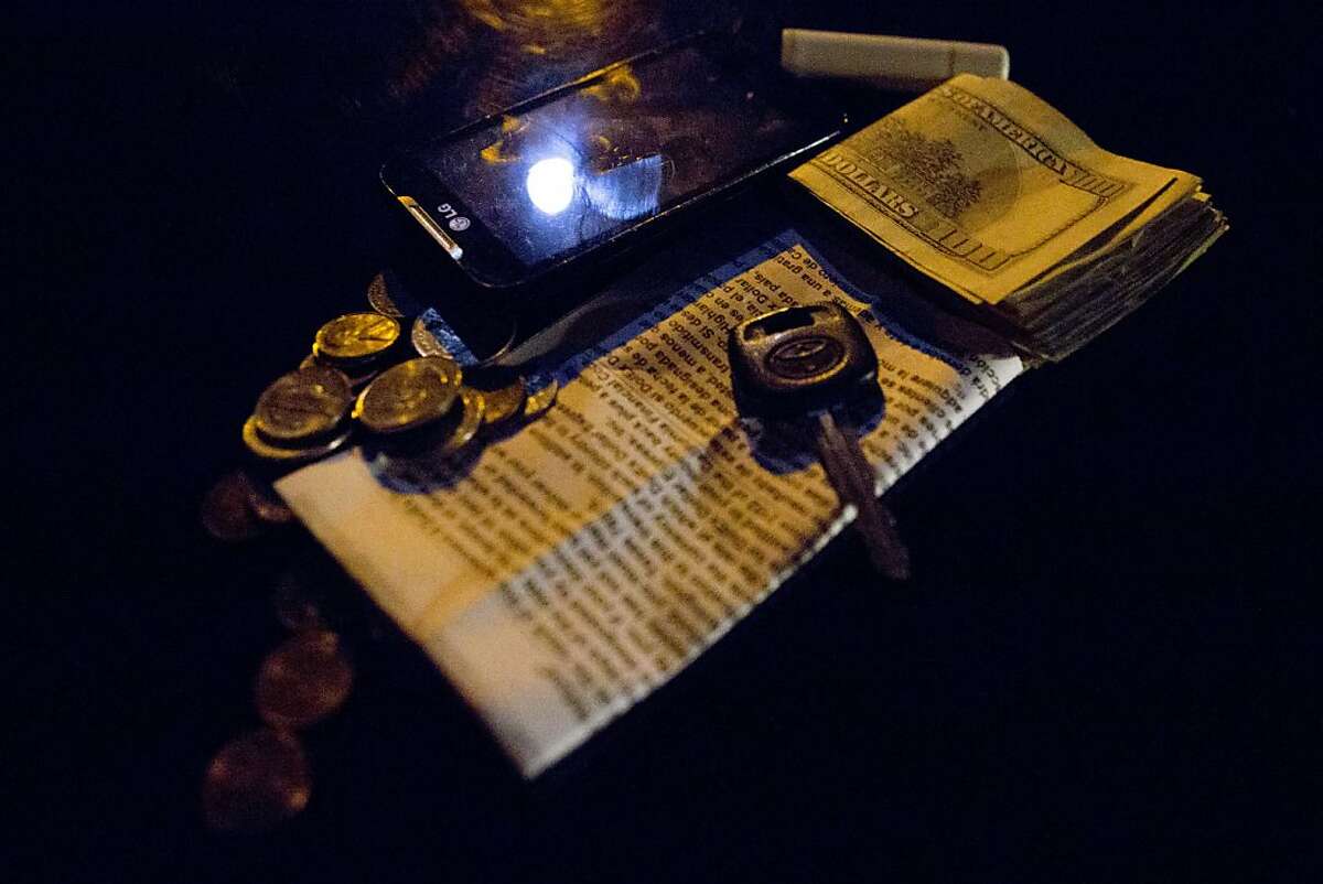The contents found in the pockets of an alleged suspect, arrested for armed carjacking, sit piled on the hood of a San Jose Police vehicle awaiting collection as evidence on Thursday, August 30, 2012 in San Jose, Calif. The suspect was apprehended while stripping the minivan in the driveway of his home in East San Jose.
