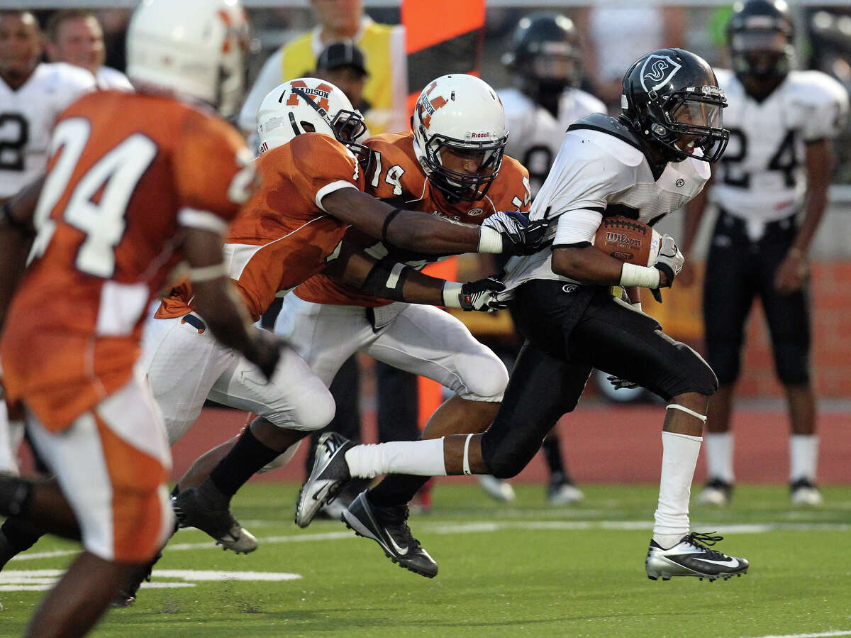 Steele's D'Angelo Wallace (21) attempts to break the grasps of Madison's Marquis Warford (04) and Lavelle Delahoussaye (14) in the first half at Heroes Stadium on Friday, August 31, 2012.