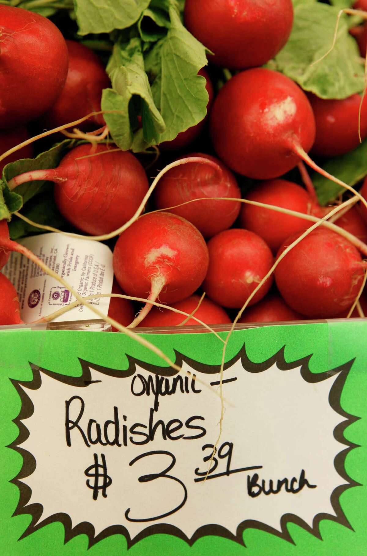 FILE - This March 16, 2011, file photo shows organic radishes at the Pacifica Farmers Market in Pacifica, Calif. Patient after patient asked: Is eating organic food, which costs more, really better for me? Unsure, Stanford University doctors dug through reams of research to find out _ and concluded there's little evidence that going organic is much healthier, citing only a few differences involving pesticides and antibiotics. Eating organic fruits and vegetables can lower exposure to pesticides, including for children _ but the amount measured from conventionally grown produce was within safety limits, the researchers reported Monday, Sept. 3, 2012. (AP Photo, File)