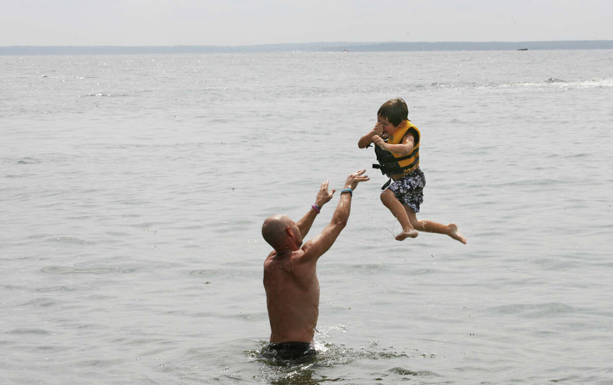 Jason Brasher, of Bridgeport, throws his son, Diego, 5, into the air at the annual Arthur J. Ladrigan Swim Races and Family Fun Day at Bayley Beach in Rowayton, Conn. on Sunday, September 2, 2012.