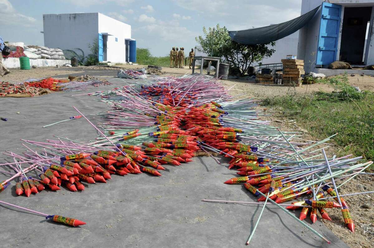 Fireworks lie in the foreground as policemen arrive at the scene after a massive blaze swept through the Om Siva Shakti fireworks factory in Sivakasi, about 650 kilometers (400 miles) southwest of Chennai, India, Wednesday, Sept.5, 2012. Large amounts of firecrackers and raw materials were stored in the factory with major Hindu festivals weeks away. Dozens of workers were killed and dozens were injured in the fire, the cause of which was not immediately known.(AP Photo)