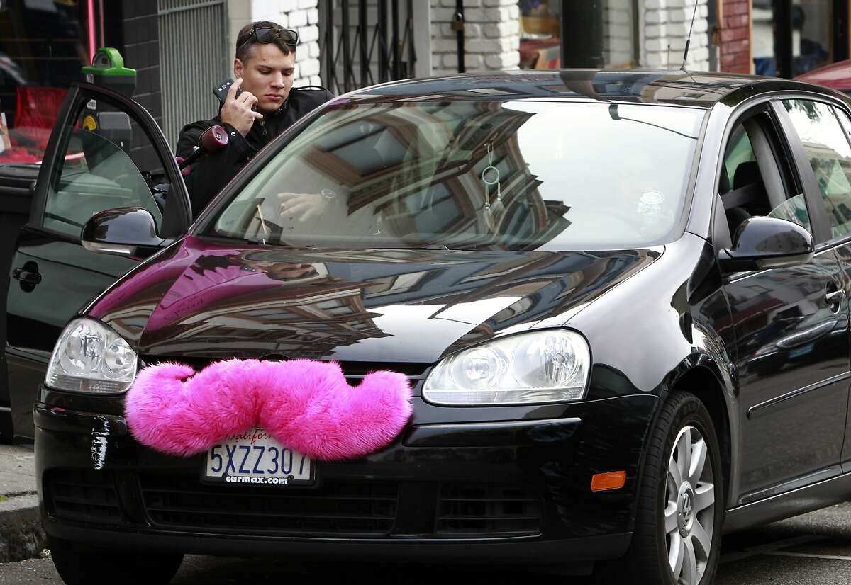Nick Riggal climbs into a car adorned with a pink moustache after requesting a ride using the Lyft car service in San Francisco, Calif. on Wednesday, Sept. 5, 2012.