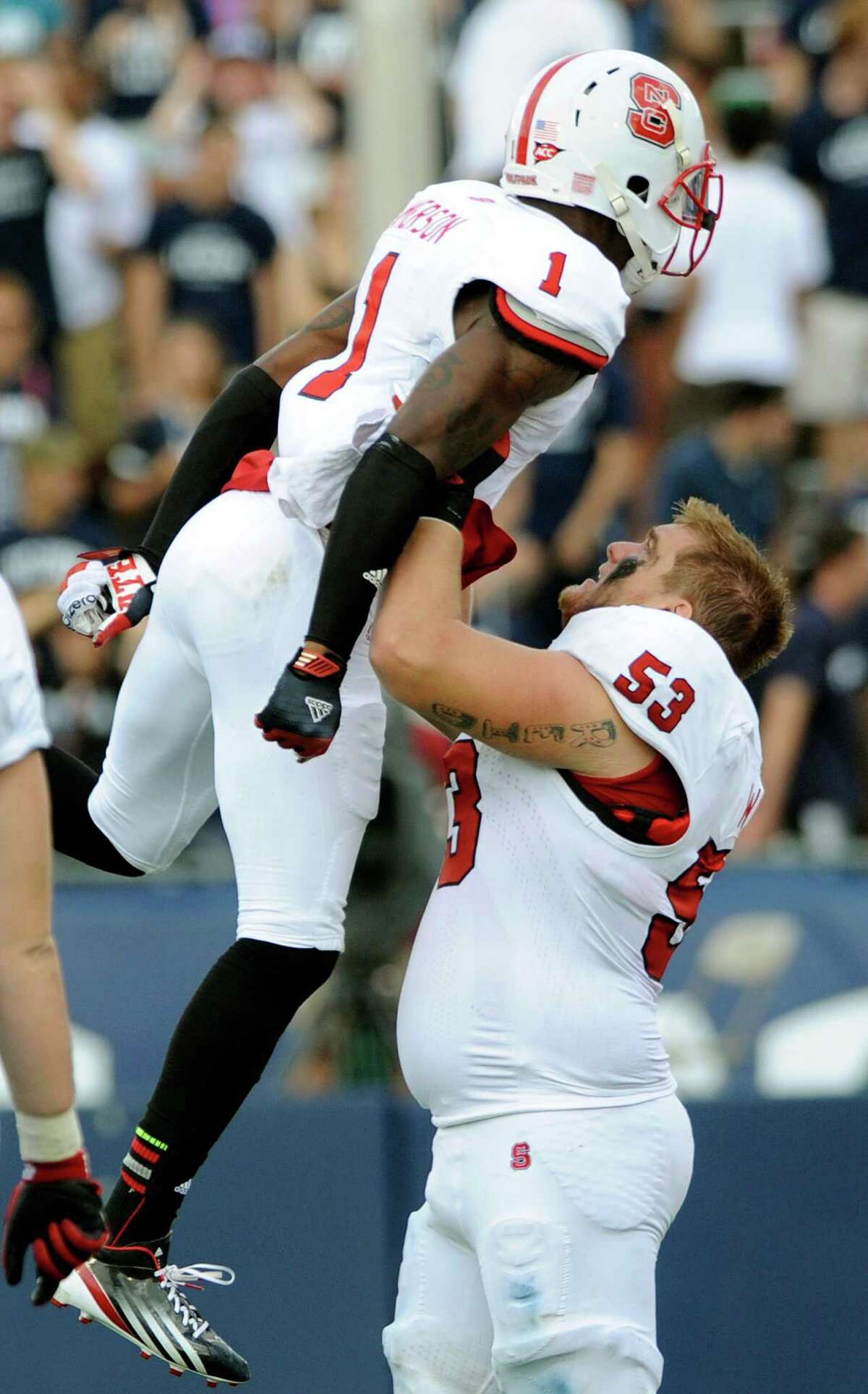 North Carolina State's David Amerson, left and Camden Wentz celebrate late in the second half of North Carolina's 10-7 victory over Connecticut in their NCAA college football game in East Hartford, Conn., on Saturday, Sept. 8, 2012. (AP Photo/Fred Beckham)