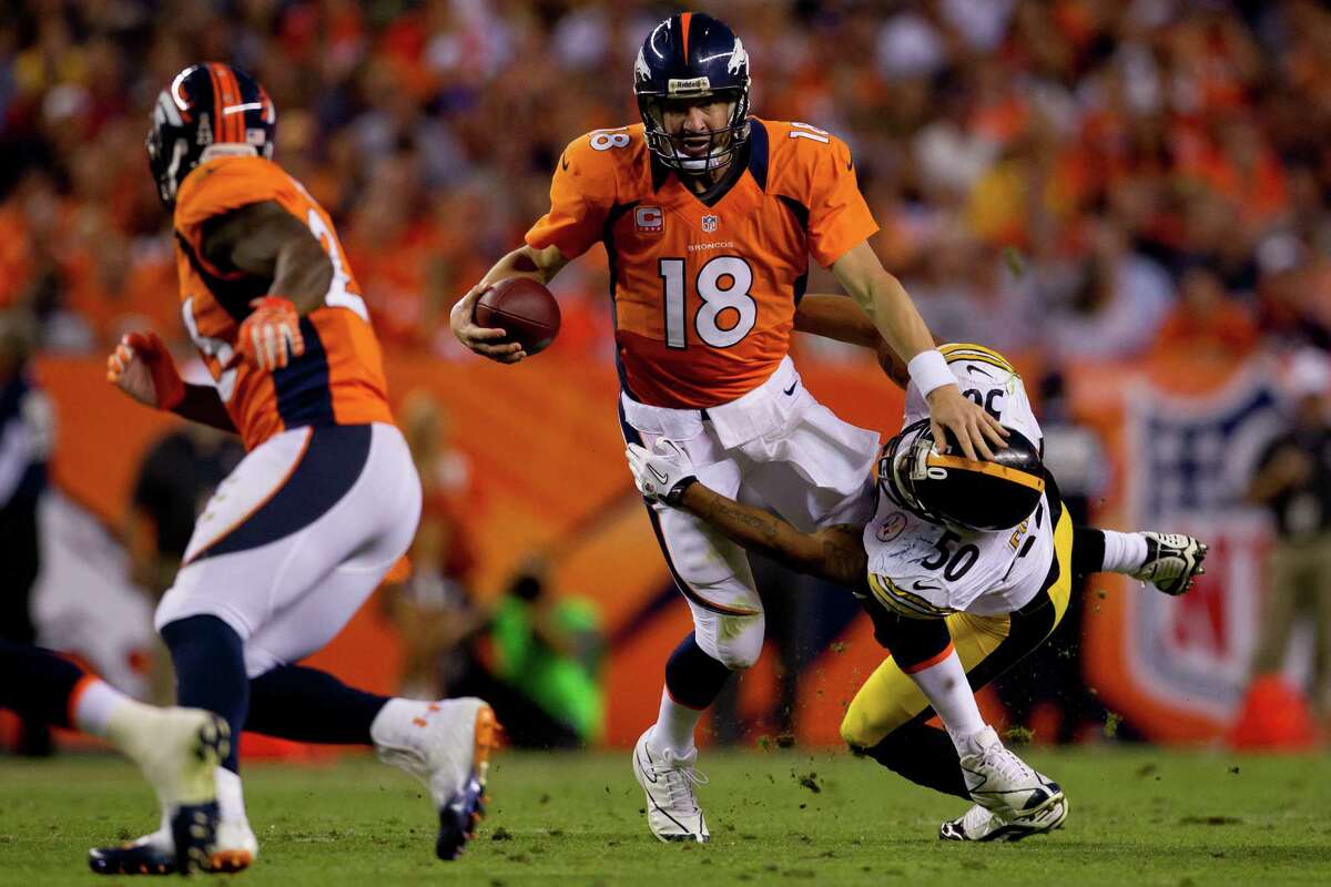 Denver Broncos quarterback Peyton Manning (18) sits on the bench