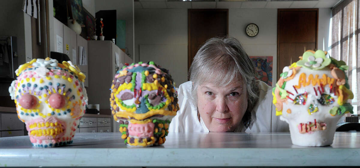 Sandi Laurette, education curator at the Art Museum of Southeast Texas, shows off a few of the culinary crafts made at previous Sugar Skulls Workshops. Today's event includes teaching guests to make the skulls and a Thursday session will allow for decoration. The skulls are made as decorations for the Day of the Dead celebration. Photo taken Monday, September 10, 2012 Guiseppe Barranco/The Enterprise