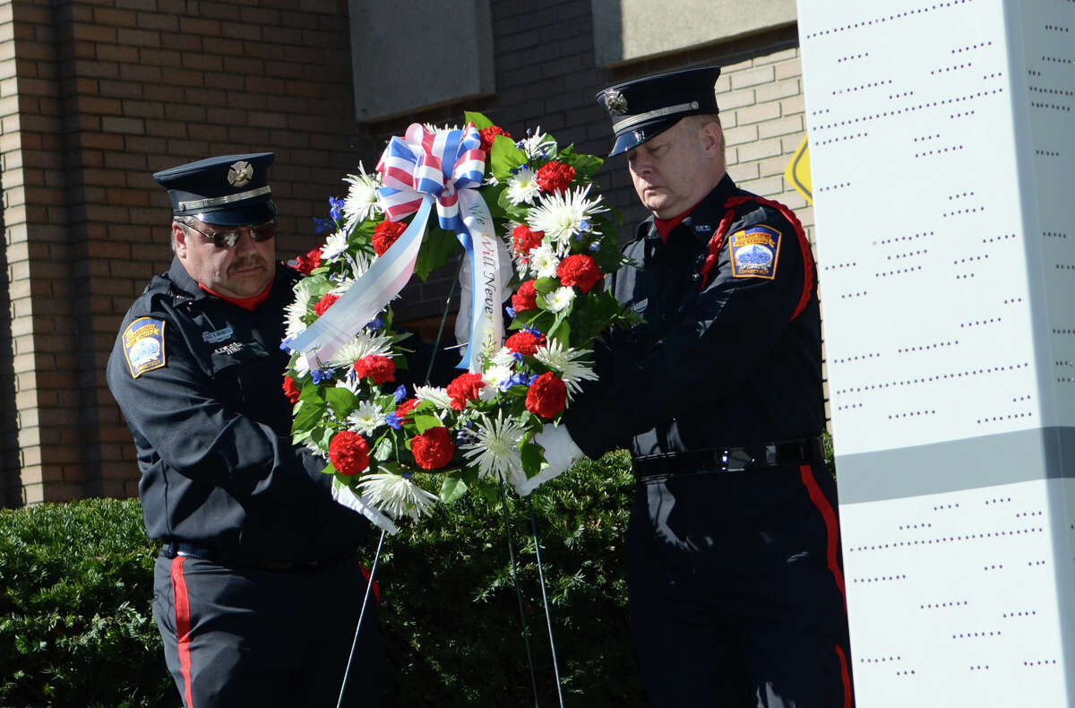 Firefighter Dave Bocchetta, Engine 2, and retired firefighter Ricky Gillespie, place a wreath near the 9/11 Twin Towers memorial during the Stamford Fire & Rescue Department (SFR) and the Stamford Professional Fire Fighters Association 9/11 Memorial Observance in front of Station 5 on Washington Blvd. in Stamford on Tuesday, Sept. 11, 2012.