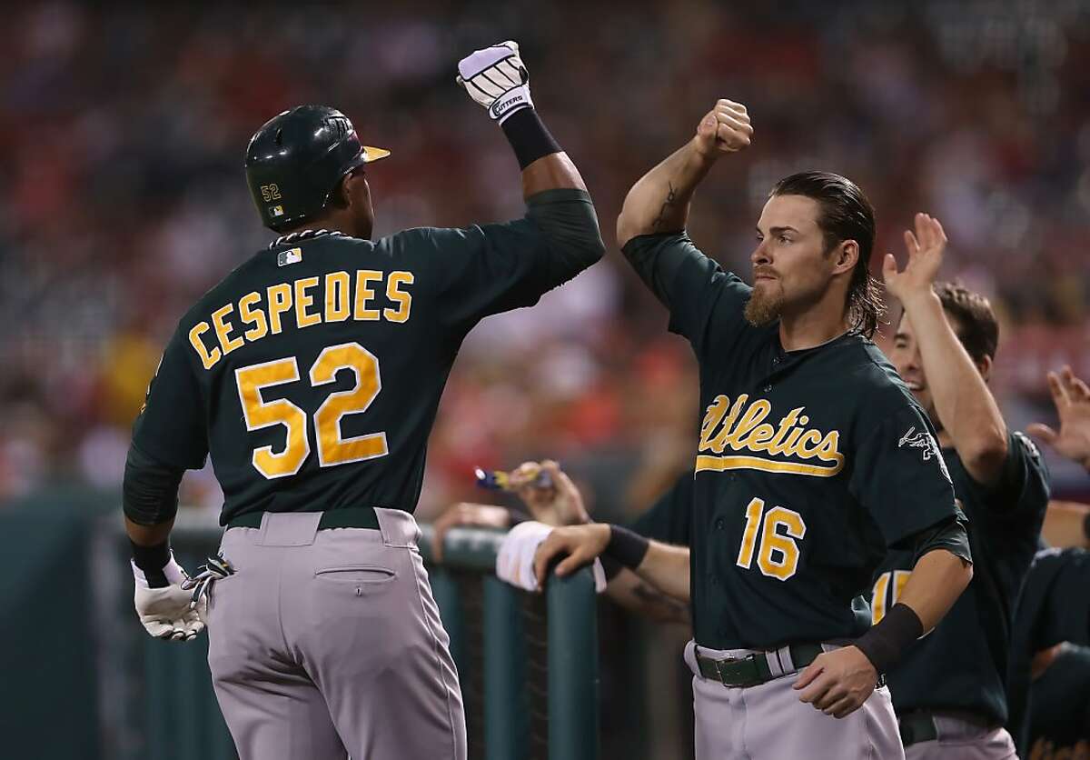 ANAHEIM, CA - SEPTEMBER 11: Yoenis Cespedes #52 of the Oakland Athletics receives a high five from teammate Josh Reddick #16 after hitting a solo home run against the Los Angeles Angels of Anaheim in the second inning at Angel Stadium of Anaheim on September 11, 2012 in Anaheim, California. (Photo by Jeff Gross/Getty Images)
