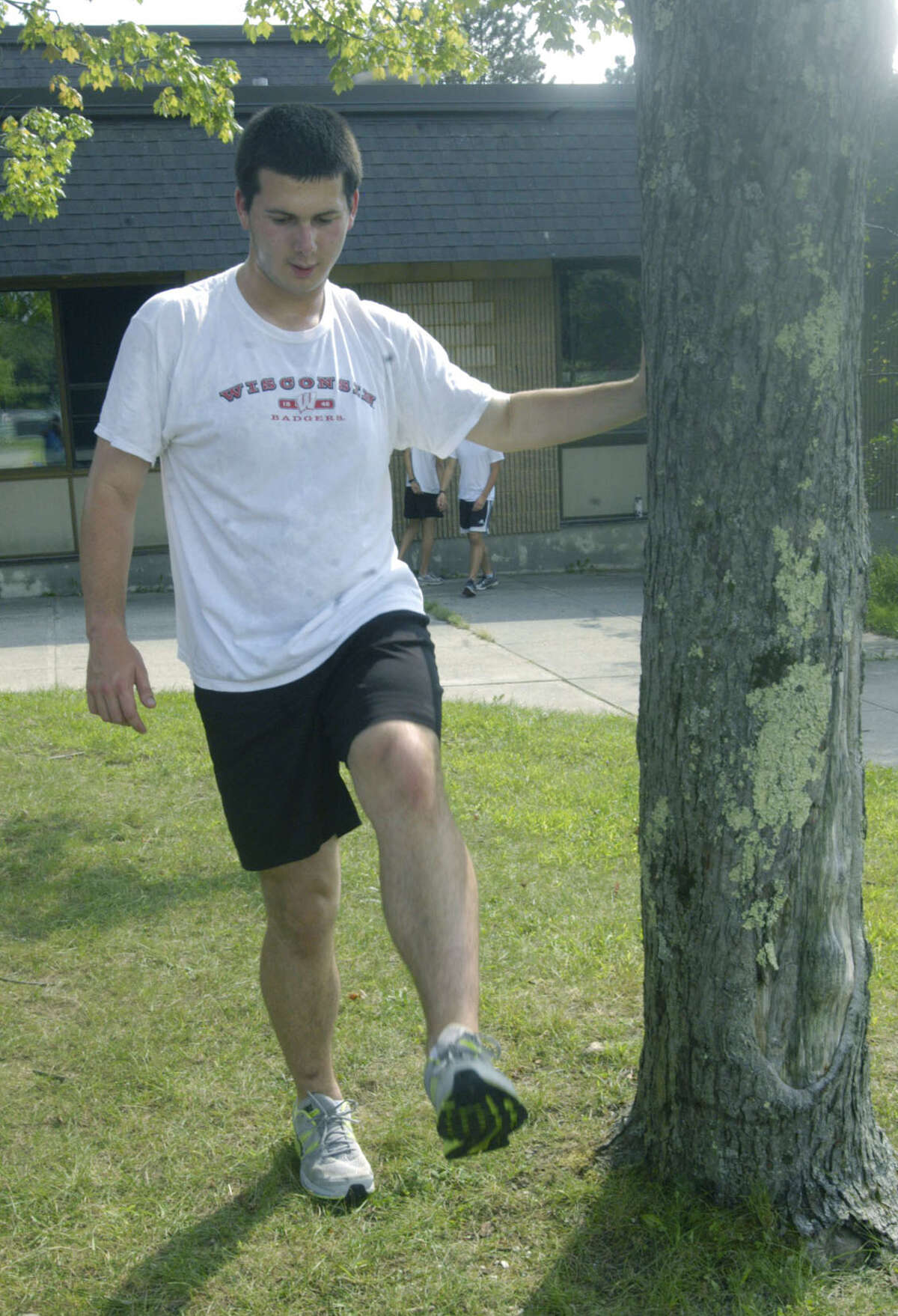 The Spartans' Ben Levine works out the kinks in preparation for a pre-season workout for Shepaug Valley High School boys' cross country. September 2012