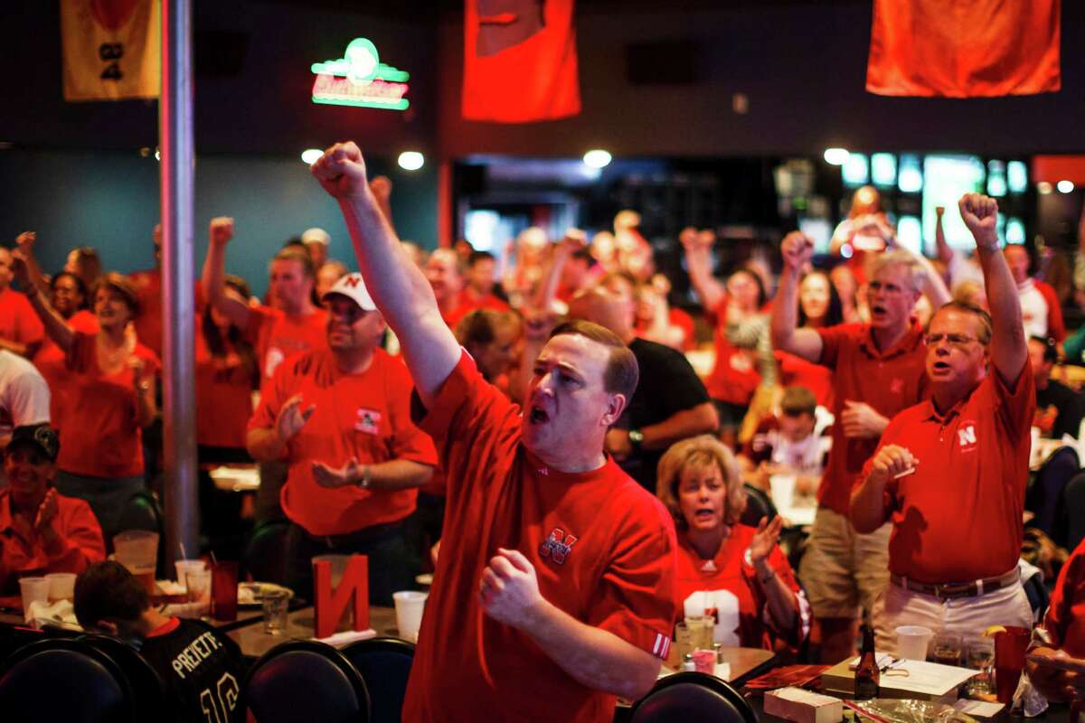 Roy Fiala cheers on the Nebraska Cornhuskers as he and other fans watch the Nebraska vs. UCLA college football game while sitting at the SRO Sports Bar & Cafe, Saturday, Sept. 8, 2012, in Houston. ( Michael Paulsen / Houston Chronicle )