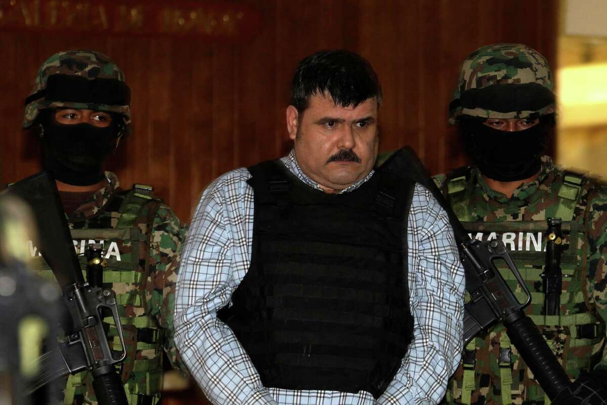 Mexican Navy marines escort Jorge Eduardo Costilla Sanchez, aka "El Coss," as he is shown to the press at the Mexican Navy's Center for Advanced Naval Studies in Mexico City,Thursday, Sept. 13, 2012. Costilla is believed to be the alleged leader of the Gulf drug cartel. One of Mexico's most-wanted men, the 41-year-old is charged in the U.S. with drug-trafficking and threatening U.S. law enforcement officials. U.S. authorities offered $5 million for information leading to his arrest.