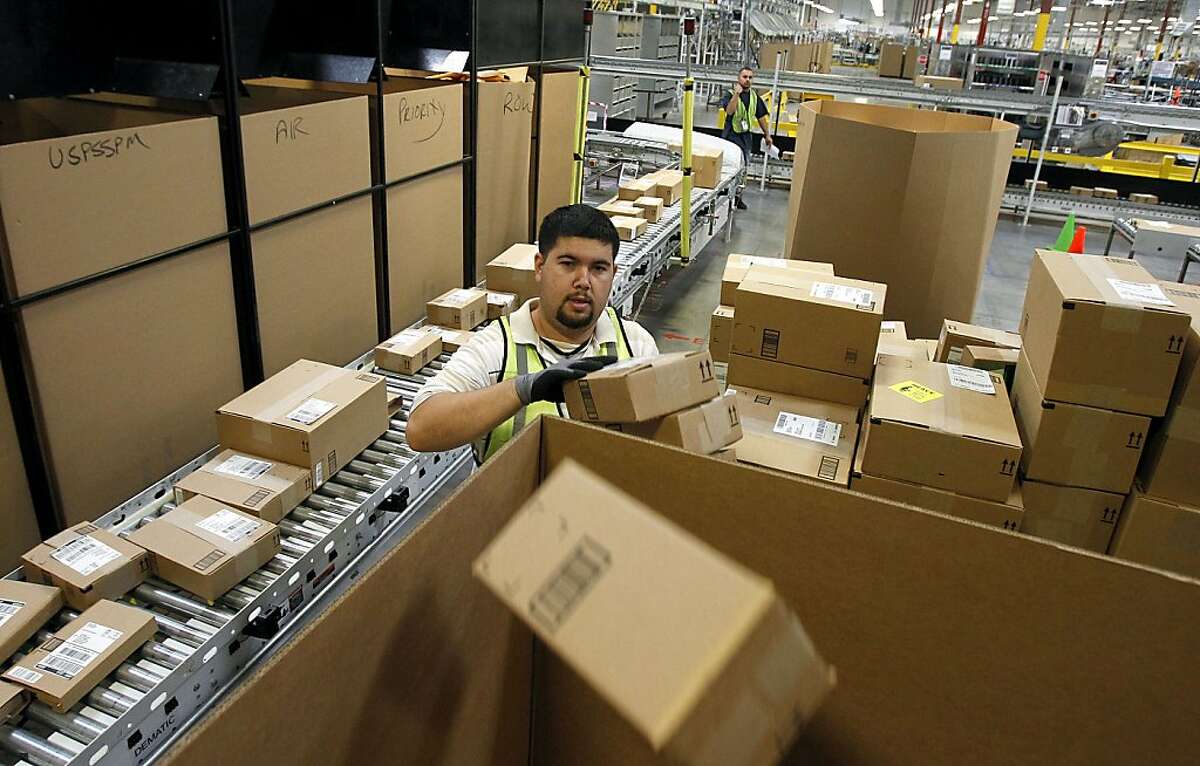 FILE - In this Nov. 11, 2010 file photo, Ricardo Sandoval places packages in the right shipping boxes at an Amazon.com fulfillment center, in Phoenix. Products are flying off the shelves at Amazon warehouses across the county as Californians prepare to start paying sales taxes on online purchases. The change, which takes effect Saturday, Sept. 15, 2012, will pave the way for the e-commerce giant to open warehouses in California and offer same-day shipping to customers. (AP Photo/Ross D. Franklin, file)