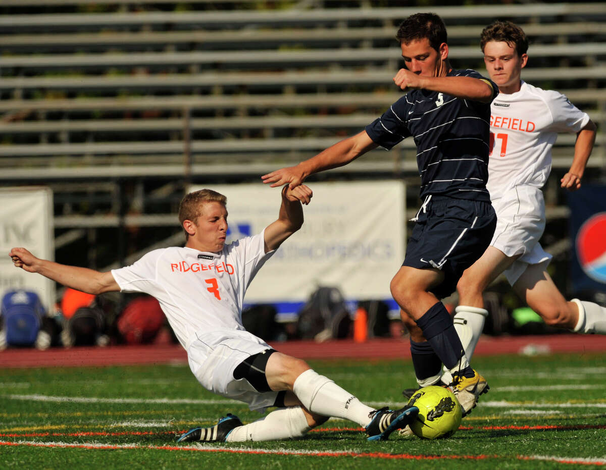Ridgefield defender Travis Leiter clears the ball away from Staples' Joe Greenwald during their game at Ridgefield High School on Thursday, Sept. 13, 2012. Ridgefield won, 2-1.