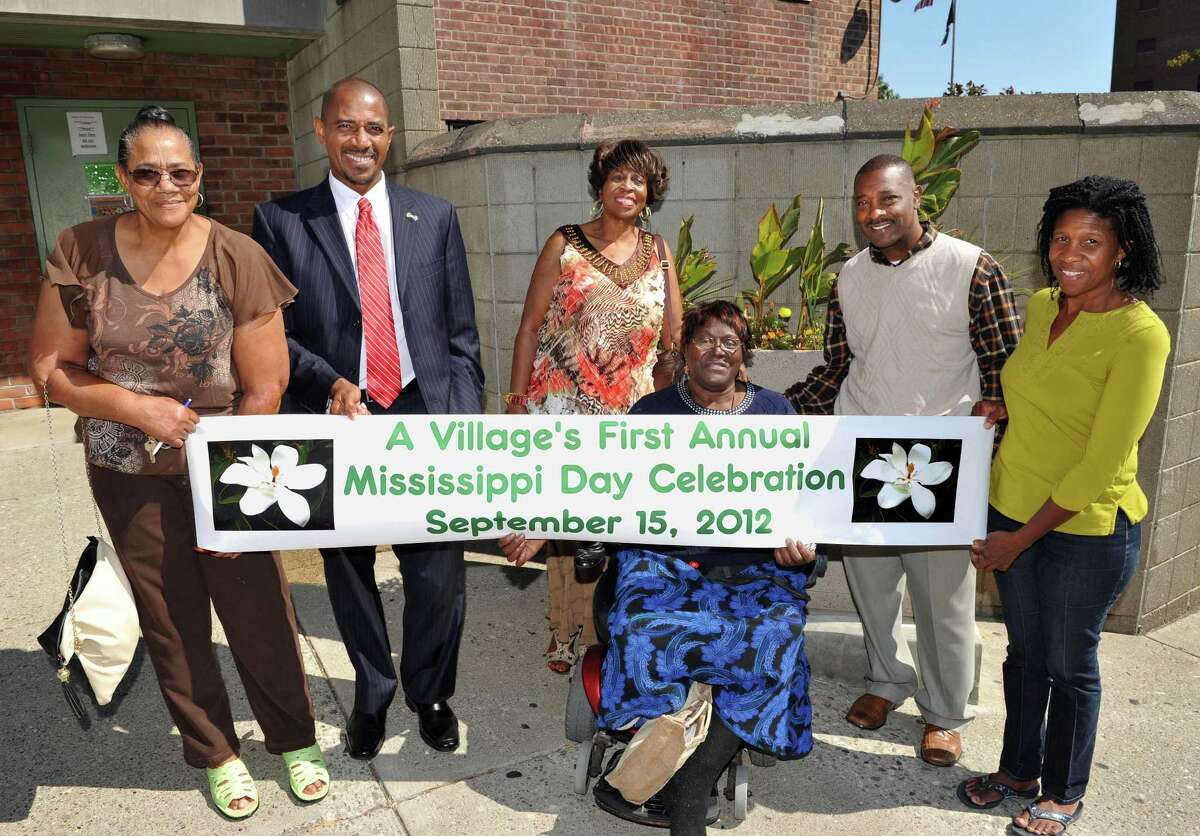 A Village organizers, from left, Clara Phillips Mark Bobb-Semple, Anne Pope, Bessie Thompson, Willie White, and Noelene Smith pose outside 3 Lincoln Square in Albany Thursday Sept. 13, 2012, with a banner for this Saturday's Mississippi Day Celebration. (John Carl D'Annibale / Times Union)