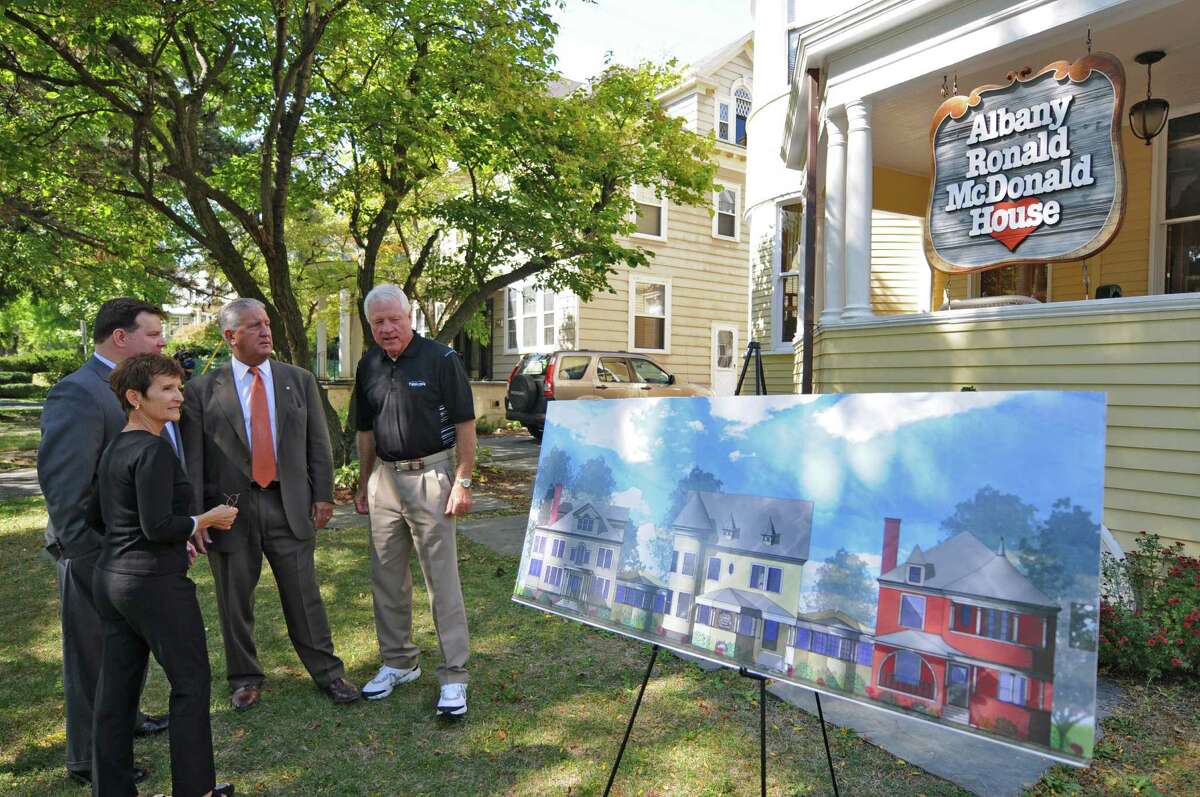 Ronald McDonald House Charities of the Capital Region Executive Director Jeff Yule, left, and Albany Mayor Jerry Jennings, second from right, stand with Fred Hill, right, and his wife Fran, parents of the child who was the inspiration for the first Ronald McDonald House in Philadelphia in 1974, as they look at plans for an expansion of the current facility on South Lake Avenue to include the house behind them at left, during an announcement on Thursday Sept. 13, 2012 in Albany, NY. (Philip Kamrass / Times Union)
