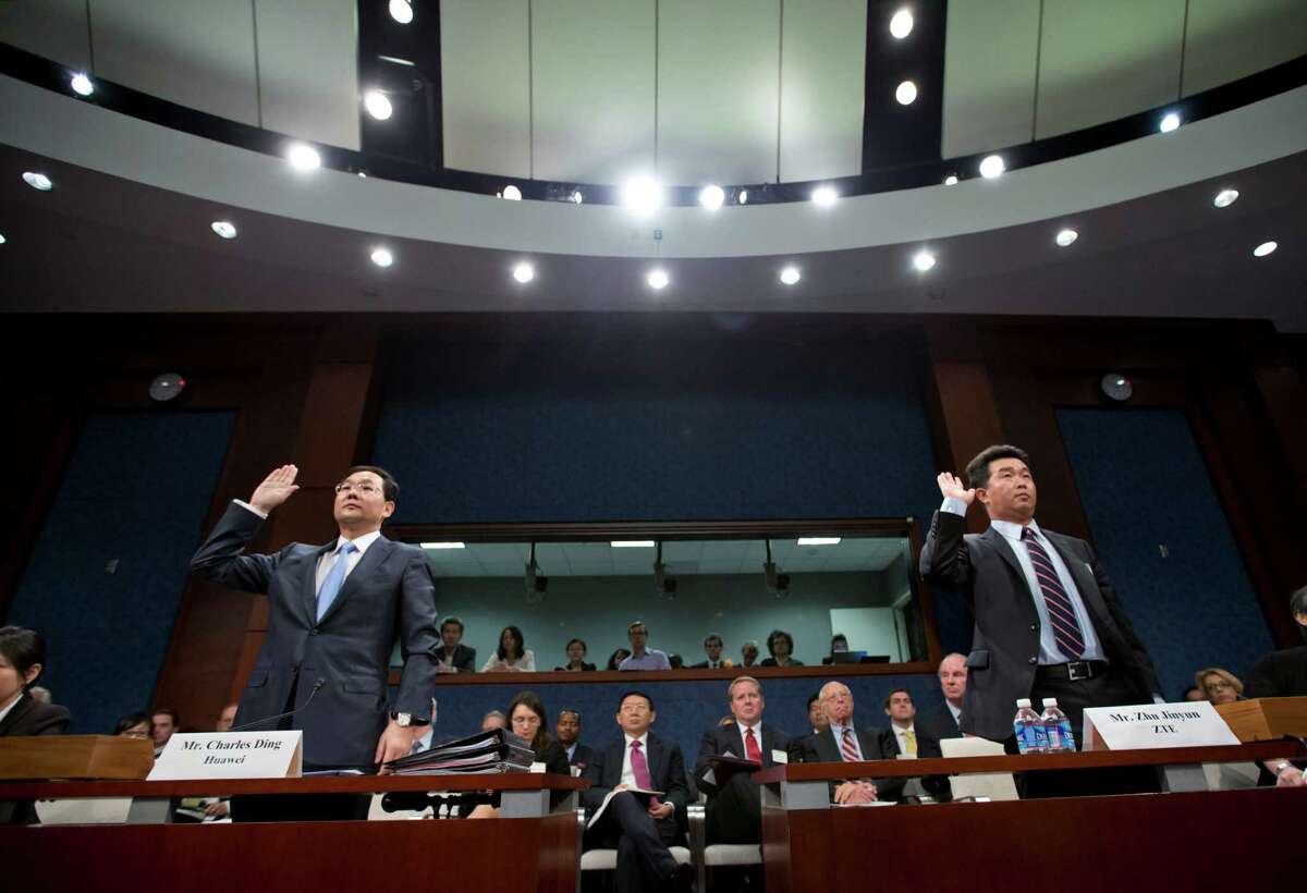 Executives of two major Chinese technology companies, Charles Ding, Huawei Technologies Ltd senior vice president for the U.S., left, and Zhu Jinyun, ZTE Corporation senior vice president for North America and Europe, are sworn in on Capitol Hill in Washington, Thursday, Sept. 13, 2012, prior to testifying before the House Intelligence Committee as lawmakers probe whether their expansion in the U.S. market poses a threat to national security. (AP Photo/J. Scott Applewhite)