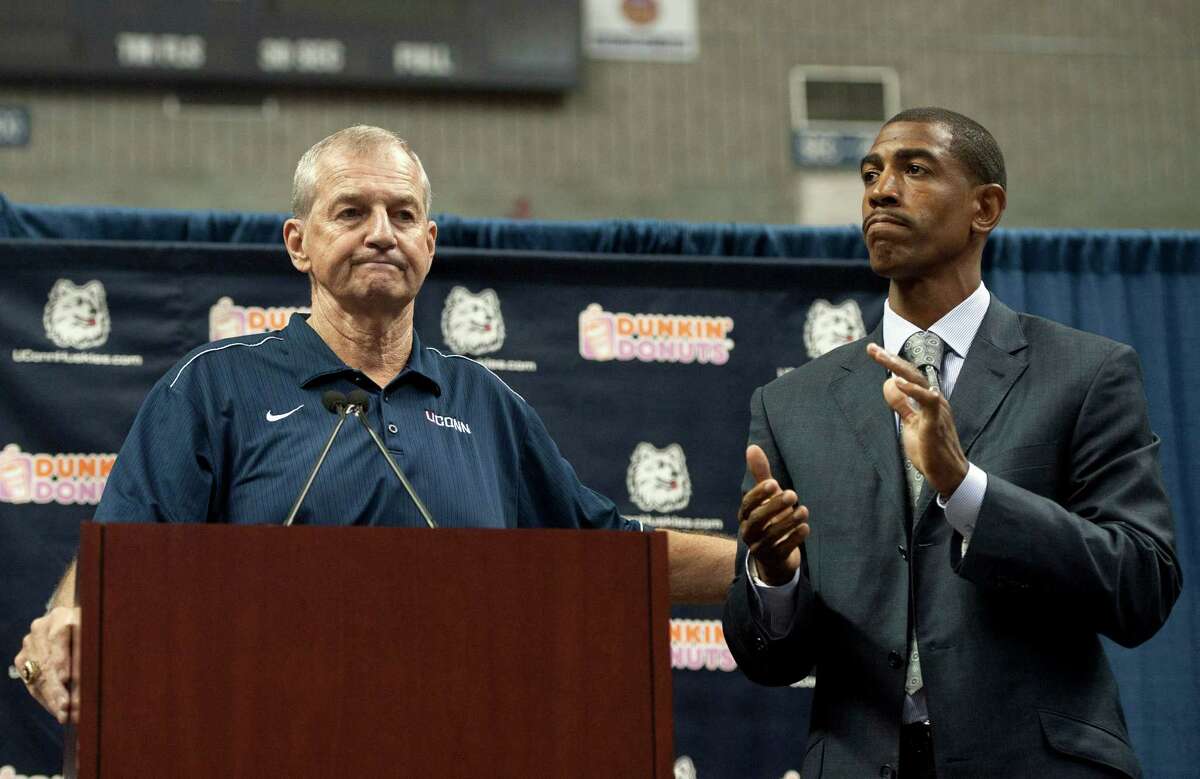 Connecticut head coach Jim Calhoun, left, reaches out to as Kevin Ollie, right, during a news conference announcing Calhoun's retirement, Thursday, Sept. 13, 2012, in Storrs, Conn. Ollie, an assistant coach under Calhoun, will succeed him. (AP Photo/Jessica Hill)