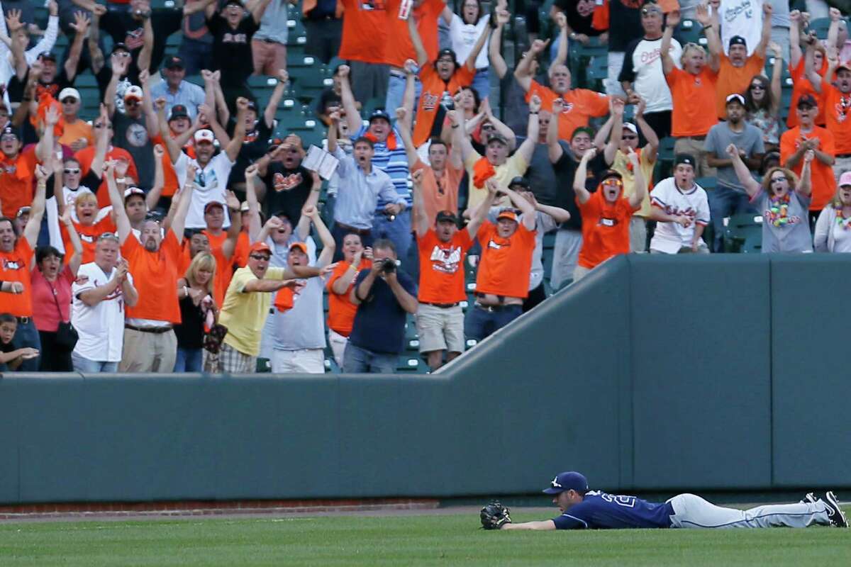 Orioles fans cheer as Matt Joyce of the Rays can't reach the blooper hit by Manny Machado that drove in the winning run in the 14th inning at Camden Yards.