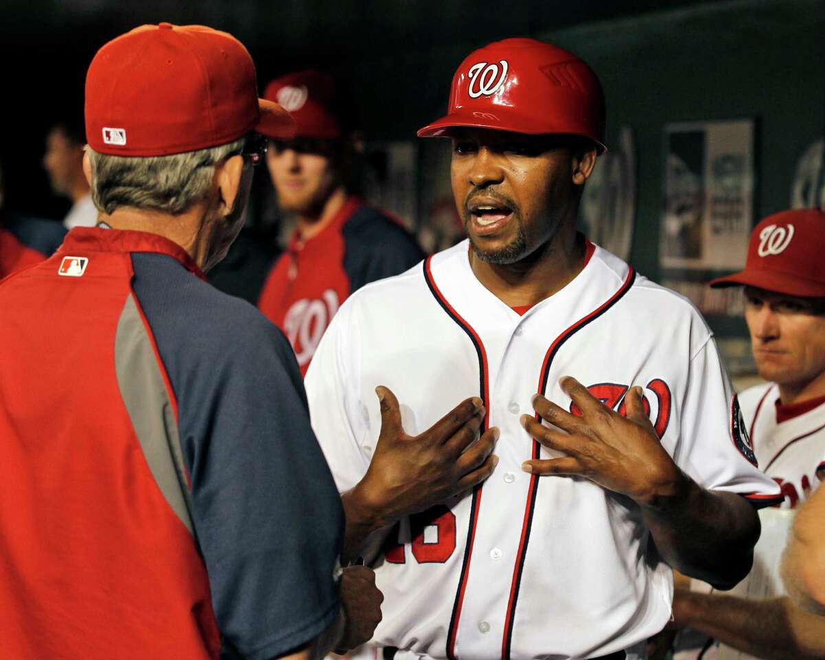 Washington Nationals manager Davey Johnson, left, listens to third base coach Bo Porter during a baseball game with the Chicago Cubs at Nationals Park Thursday, Sept. 6, 2012, in Washington. The Nationals won 9-2. (AP Photo/Alex Brandon)
