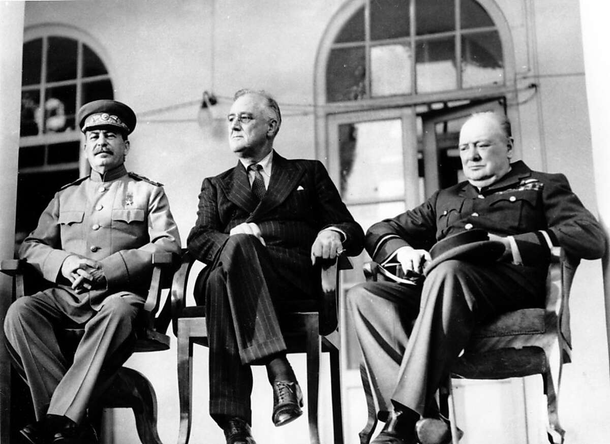 FILE - In this Nov. 28, 1943 file photo, Soviet Union Premier Josef Stalin, U.S. President Franklin D. Roosevelt, center, and British Prime Minister Winston Churchill sit together during the Tehran Conference in Tehran, Iran. The three leaders, meeting for the first time, discussed Allied plans for the war against Germany and for postwar cooperation in the United Nations. Two American POWs sent secret coded messages to Washington with news of a Soviet atrocity: In 1943 they saw rows of corpses in an advanced state of decay in the Katyn forest, on the western edge of Russia, proof that the killers could not have been the Nazis who had only recently occupied the area. The testimony about the infamous massacre of Polish officers might have lessened the tragic fate that befell Poland under the Soviets, some scholars believe. Instead, it mysteriously vanished into the heart of American power. The long-held suspicion is that President Franklin Delano Roosevelt didn't want to anger Josef Stalin, an ally whom the Americans were counting on to defeat Germany and Japan during World War II. (AP Photo)