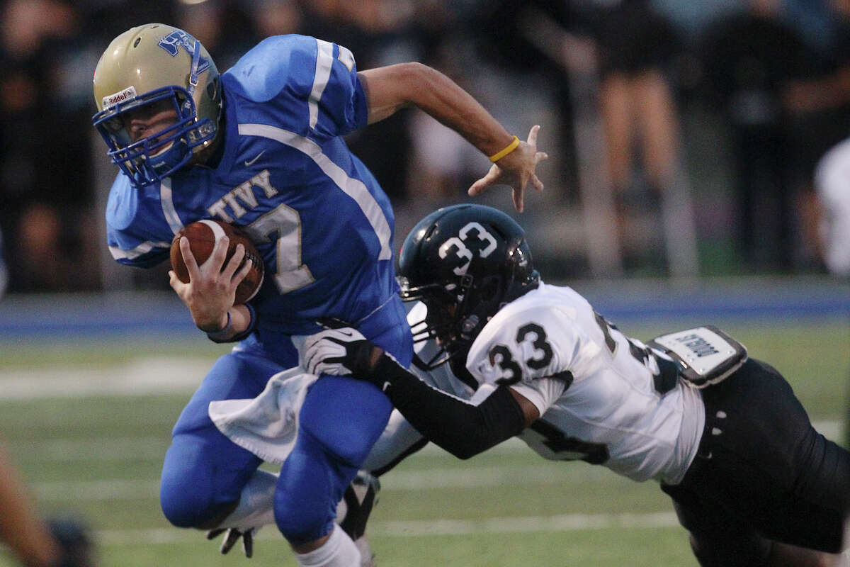 Tivy quarterback Parks McNeil (07) tries to escape a tackle by Steele's Jalen Maddox (33) during their game in Kerrville on Friday, Sept. 14, 2012.
