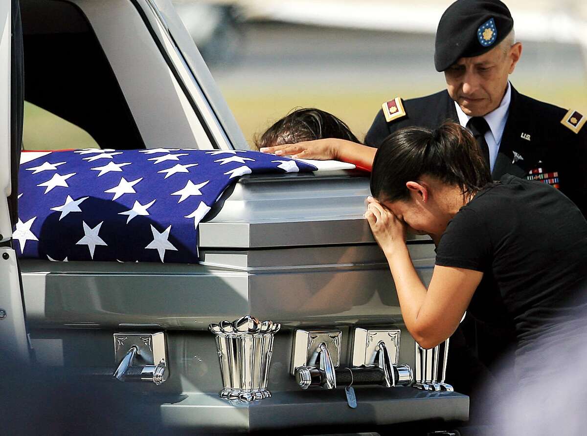 Liliana Montenegro cries over the casket of her brother, U.S. Army Warrant Officer Jose Luis Montenegro Jr., after his body arrived Sunday, Sept. 16, 2012 at McCreery Aviation in McAllen, Texas. Montenegro was stationed at Fort Bragg, N.C. and was serving his third tour of duty overseas when his helicopter was shot down in Afghanistan's Logar province. (AP Photo/The Monitor, Gabe Hernandez)