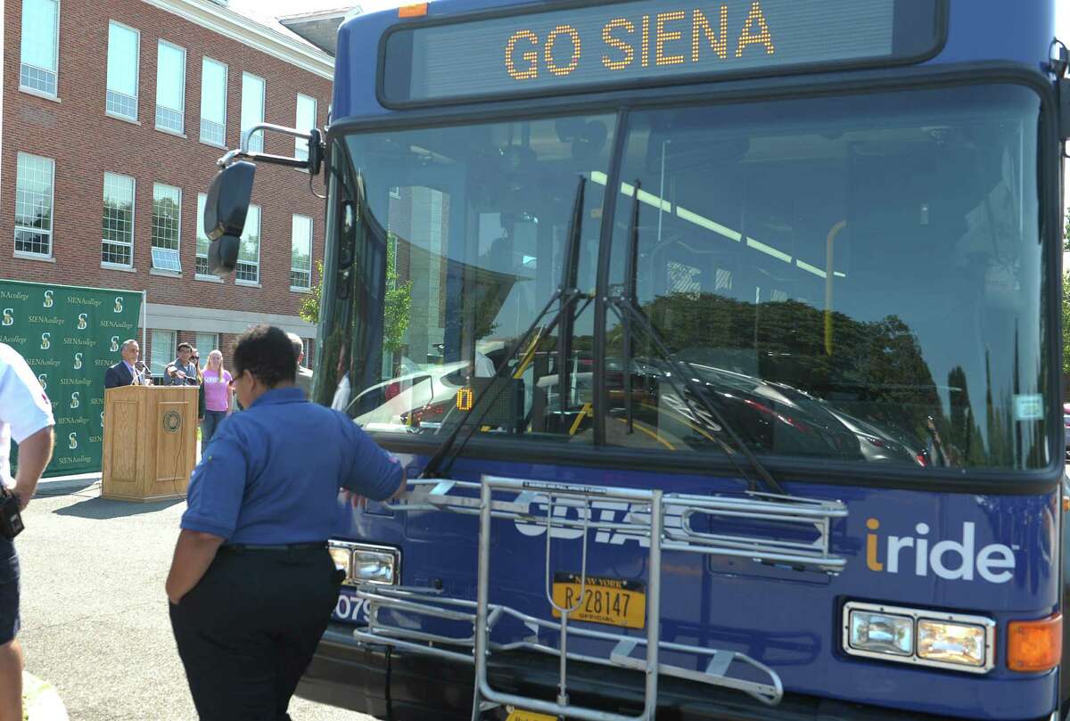 Carm Basile, background at podium, CEO of CDTA, addresses those gathered at Siena College during a press event on Monday, Sept. 17, 2012 in Loudonville, NY. CDTA and Siena announced a new program that gives Siena students access to the CDTA route system. (Paul Buckowski / Times Union)