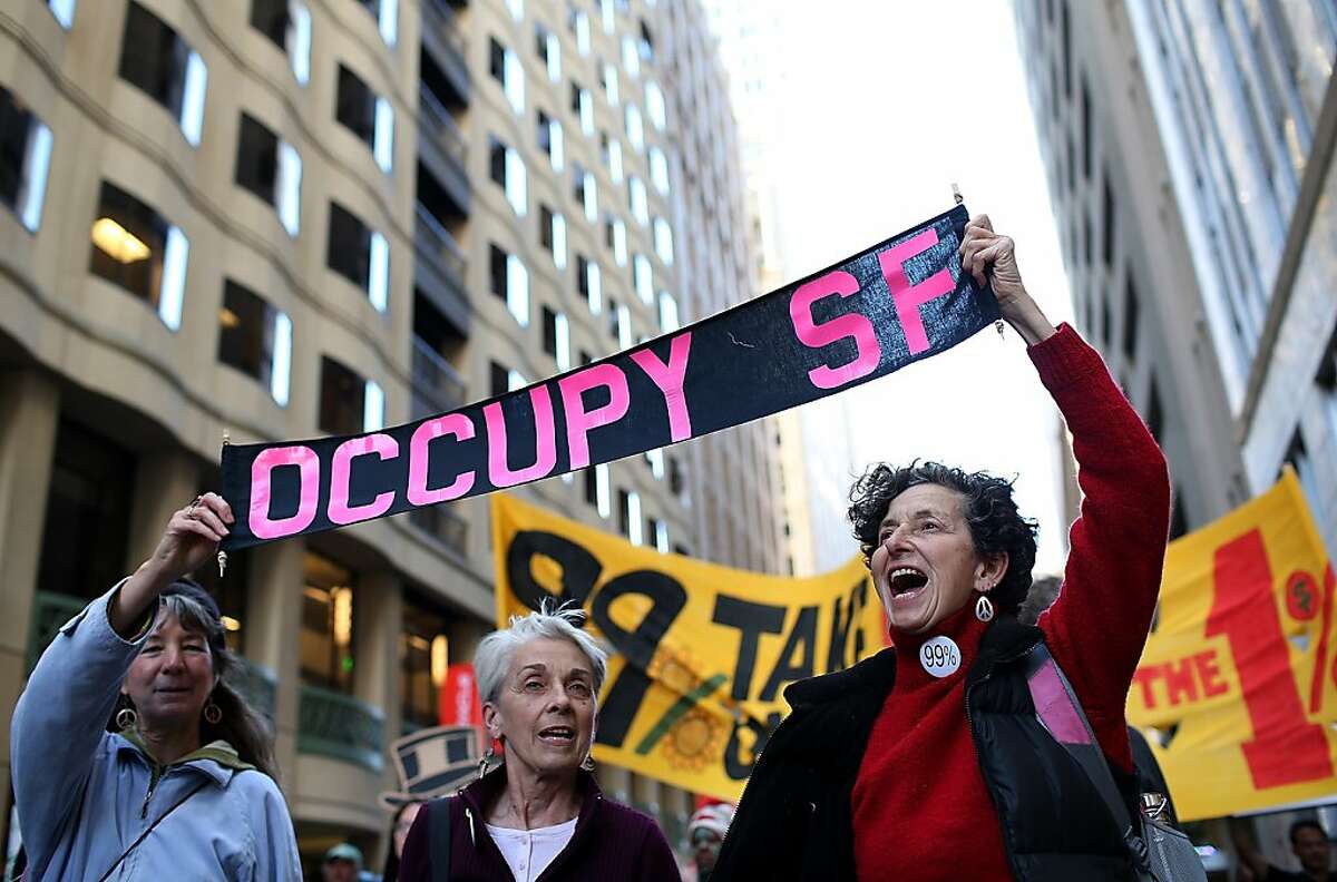 Occupy Wall Street protestors hold a sign during a demonstration on September 17, 2012 in San Francisco, California. An estimated 100 Occupy Wall Street protestors staged a demonstration and march through downtown San Francisco to mark the one year anniversary of the birth of the Occupy movement. (Photo by Justin Sullivan/Getty Images)