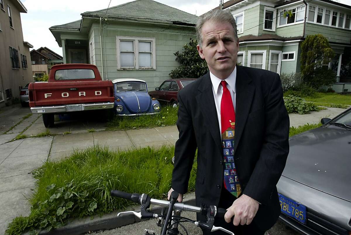Berkeley councilman Kriss Worthington stands with his his bike on Grant Street, next to a house that has cars in the front yard. A new car tax is being proposed in Berkeley for residents who own multiple cars. Event on 2/20/04 in Berkeley. Darryl Bush / The Chronicle