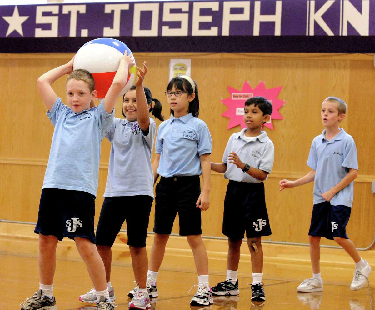 Third-graders pass a ball in gym class at St. Joseph School in Danbury Tuesday, Sept. 18, 2012. From left are Aidan Hefele, Ahushka Thakur, Abby Martin, Sean Lawrence, and Aidan Gage.