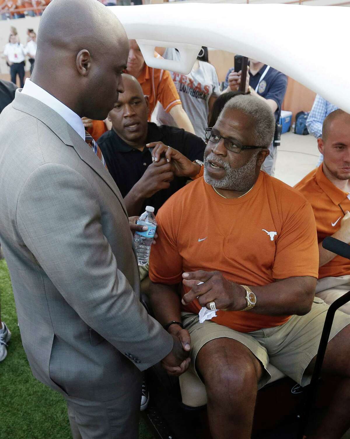FILE - In this Sept. 8, 2012 file photo, former Texas football player Earl Campbell, right, talks with Ricky Williams, left, as he prepares to take part in the coin flip prior to an NCAA college football game between Texas and New Mexico in Austin, Texas. The NFL Hall of Famer and former Heisman Trophy winner said Tuesday, Sept. 18, 2012, he is undergoing nerve treatment after doctors ruled out concerns that he might have Lou Gehrigís disease. (AP Photo/Eric Gay)