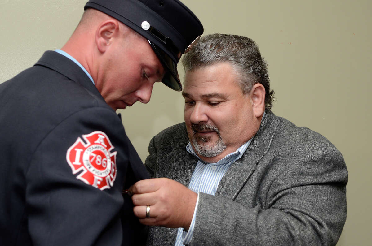 Retired firefighter Frank Docimo Sr. adjusts the pin his son, firefighter Frank Docimo, Jr. had just received as Firefighter of the Year. The award was bestowed at an award ceremony at the Gen Re Auditorium at UConn in Stamford, CT on Sept. 18, 2012.