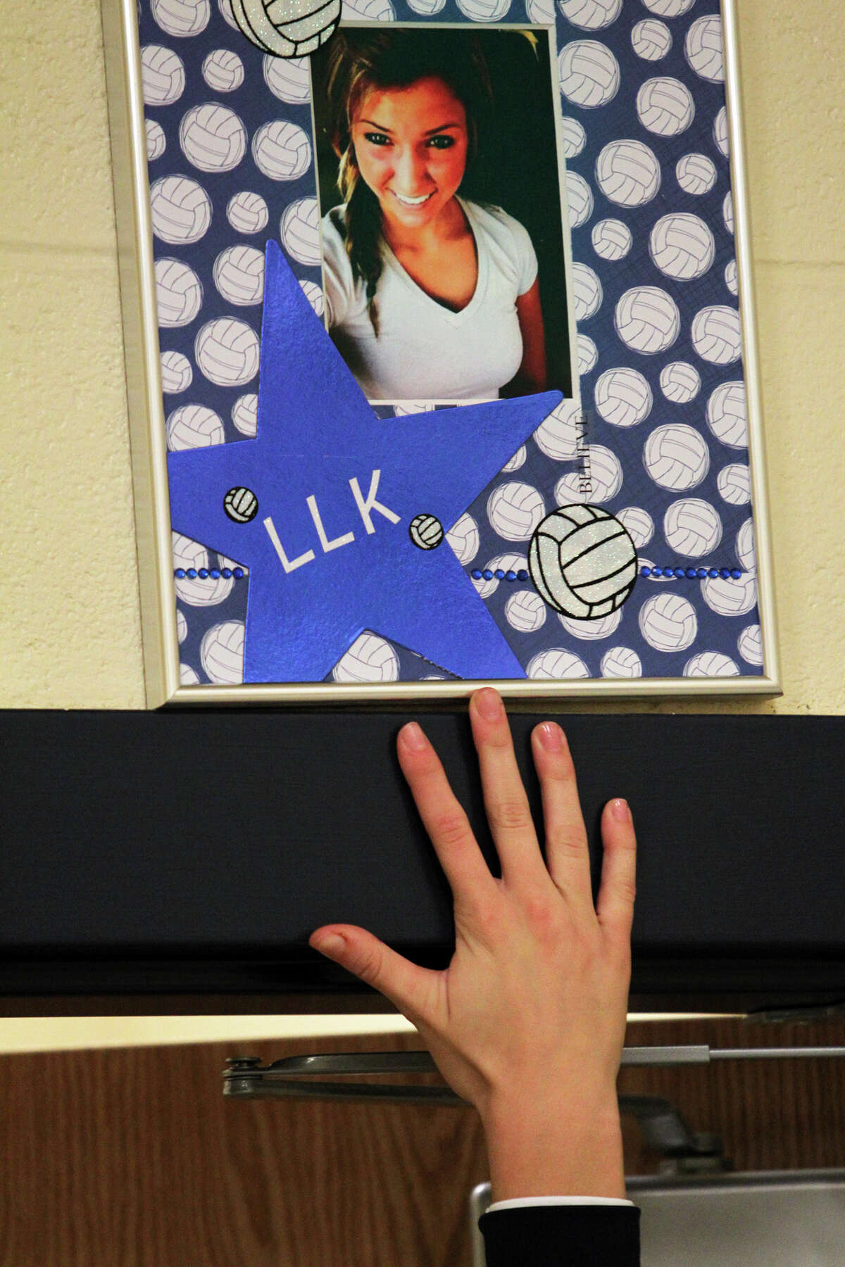 Players touch a picture while exiting the locker room as Smithson Valley volleyball players and fans remember Kali Gorzell a teammate who was killed last summer with a Live Like Kali campaign on September 18, 2012.