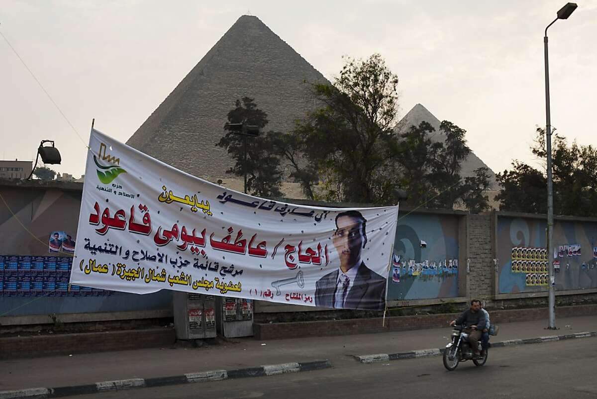 A banner supporting parliamentary candidate Aatif Bayoumy Kaoud in the upcoming Egyptian elections is displayed on a wall near the pyramids, in Giza, near Cairo, Egypt, Saturday, Nov. 26, 2011. The election begins Monday Nov. 28, and are staggered over multiple stages that conclude in March. The military said it would extend the voting period to two days for each round in an apparent effort to boost turnout due to the current unrest. (AP Photo/Bernat Armangue)