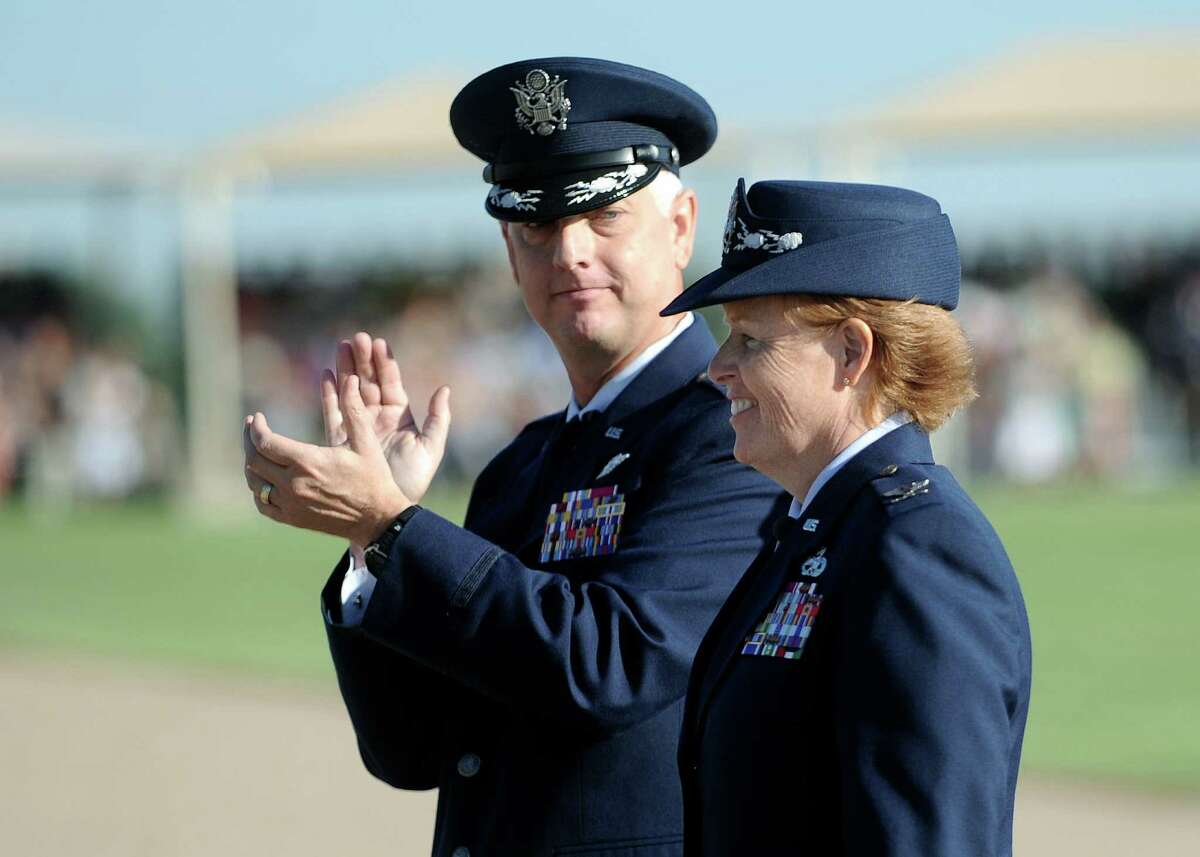 Col. Deborah Liddick, new commander of the Air Force basic training program at Lackland, is applauded by Col. Mark Camerer.