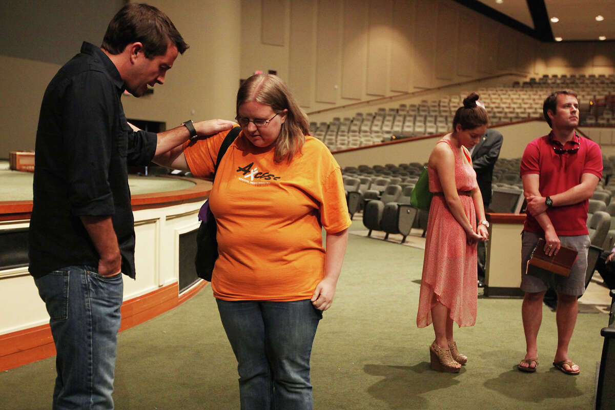 Executive pastor Chris Emmitt (left) prays with Laci Walk as Victoria Santoscoy and Travis Mayfield wait their turn after a 1 p.m. service at Community Bible Church. Emmitt is the son of senior pastor Robert Emmitt, who started the church in 1990. It has the largest congregation in San Antonio.