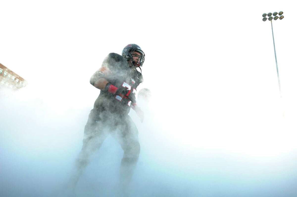 Incarnate Word linebacker Devin Threat emerges from the mist as he runs onto the Benson Stadium field for the game against West Texas A&M on Saturday, Sept. 22, 2012.