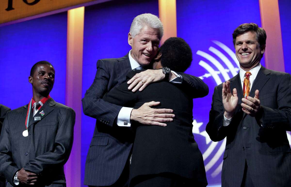 NEW YORK, NY - SEPTEMBER 23: Former U.S. President Bill Clinton (C) receives a hug from Loretta Claiborne while Special Olympian Deon Naniseb and Timothy Perry Shriver (L), Chairman and CEO of Special Olympics look on before during the session "Designing for Impact" at the Clinton Global Initiative September 23, 2012 New York City. Timed to coincide with the United Nations General Assembly, CGI brings together heads of state, CEOs, philanthropists and others to help find solutions to the world's major problems.