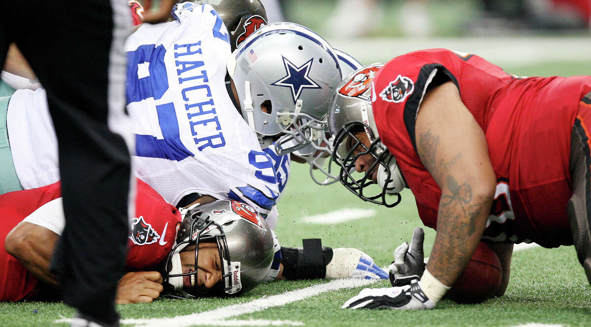 Dallas Cowboys' defensive tackle Jason Hatcher lands on top of Tampa Bay Buccaneers' quarterback Josh Freeman as defensive tackle Tyrone Crawford recovers the fumble during the second half at Cowboys Stadium in Arlington, Texas, Sunday Sept. 23, 2012. The Cowboys won 16-10.