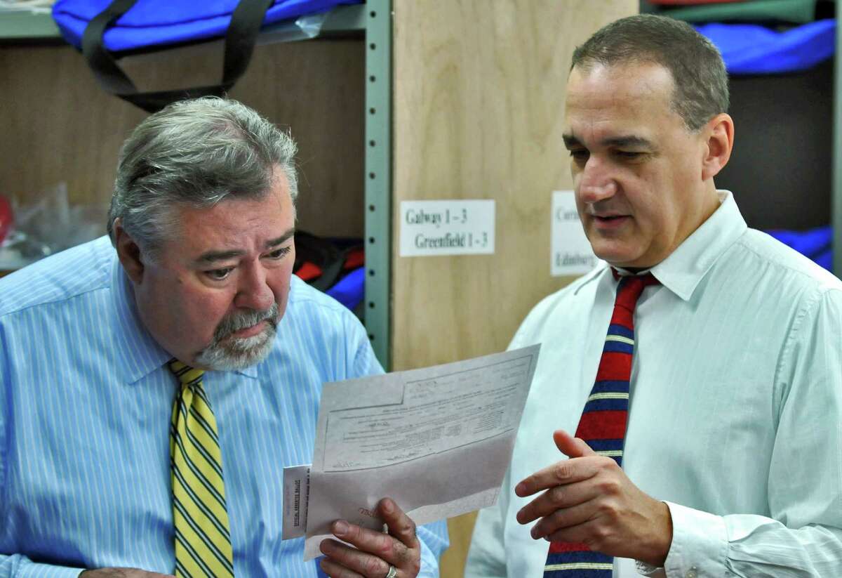 Saratoga County Election Commissioners Roger Schiera, left, and Bill Fruci, right, look over a ballot during a count of absentee ballots on Monday Sept. 24, 2012 in Ballston Spa, NY. (Philip Kamrass / Times Union)