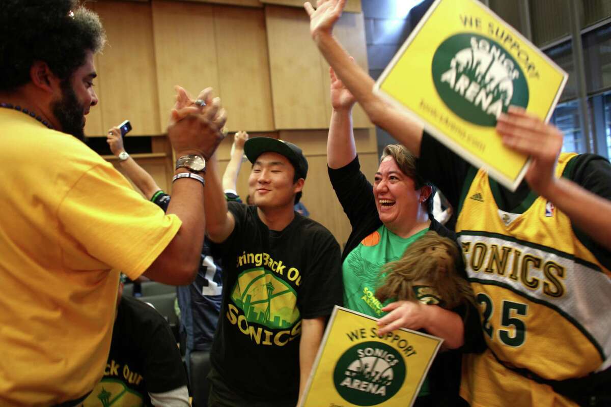 Seattle SuperSonic supporters, from left, Kris Brannon, Joseph Chong, Dawn Welch and Kenneth Knutsen celebrate as the Seattle City Council votes to approve an arena proposal on Monday, September 24, 2012 at Seattle City Hall. The vote helps pave the way for a future NBA and possibly NHL arena in Seattle.