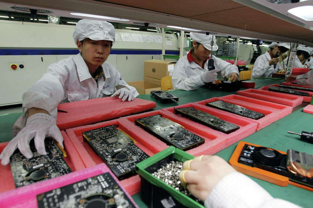 FILE - In this May 26, 2010 file photo, staff members work on the production line at the Foxconn complex in the southern Chinese city of Shenzhen. The company that makes Apple?’s iPhones suspended production at a factory in China on Monday, Sept. 24, 2012, after a brawl by as many as 2,000 employees at a dormitory injured 40 people. The fight, the cause of which was under investigation, erupted Sunday night at a privately managed dormitory near a Foxconn Technology Group factory in the northern city of Taiyuan, the company and Chinese police said. (AP Photo/Kin Cheung, File)
